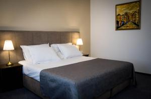 um quarto com uma cama grande e almofadas brancas em Nest em Drobeta-Turnu Severin