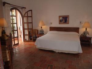 a bedroom with a white bed and a open door at Hotel Santa Fe in Puerto Escondido