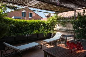 un patio con 2 sedie a sdraio e un tavolo di Ca' Navagero Apartments a Venezia