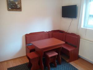 a table and chairs with a table and a television at Apartment Usović in Žabljak