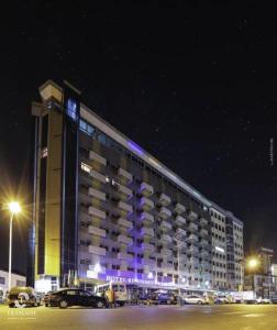 a large building with purple lights on it at night at Hotel Résidence La Falaise in Douala