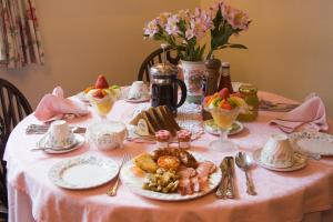a table with a pink table cloth with food on it at Park Cottage in Warwick
