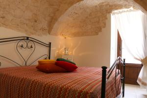 ein Schlafzimmer mit einem Bett mit bunten Kissen darauf in der Unterkunft Trulli Borgo Lamie in Locorotondo