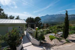 une maison avec un jardin et des montagnes en arrière-plan dans l'établissement Apartments Mokalo, à Orebić