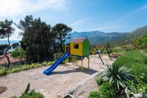une aire de jeux avec un toboggan et une structure de jeu dans l'établissement Apartments Mokalo, à Orebić