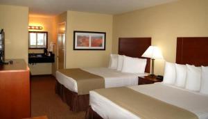 a hotel room with two beds and a desk at Southern Inn and Suites Kermit in Kermit