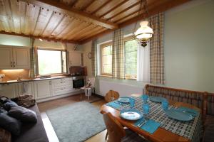 a living room with a table and a kitchen at HAUS LÄRCHEGG Wellness Apartments in Bad Kleinkirchheim