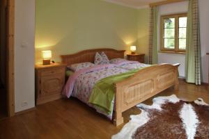 a bedroom with a wooden bed and two night stands at HAUS LÄRCHEGG Wellness Apartments in Bad Kleinkirchheim