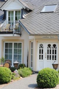 a house with a white door and a balcony at Landhaus Kuntz in Lieser