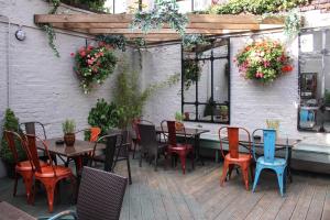 un patio al aire libre con mesas, sillas y flores en The Loopy Shrew en Shrewsbury