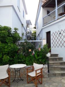 une table et des chaises devant un bâtiment dans l'établissement Kastro Studios, à Skopelos