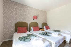 two beds in a room with white and red pillows at Guest House Porto Clerigus in Porto