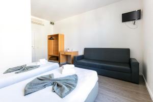 a living room with two beds and a couch at Guest House Porto Clerigus in Porto