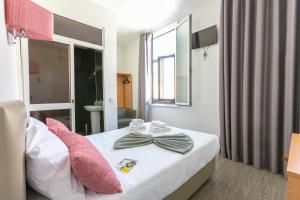 a bedroom with a bed with a bow tie on it at Guest House Porto Clerigus in Porto
