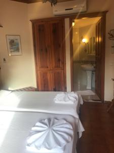 Schlafzimmer mit einem Bett mit weißer Bettwäsche und einem Waschbecken in der Unterkunft Asur Hotel & Aparts & Villas in Dalyan