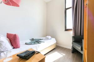 a room with a bed with a phone on a table at Guest House Porto Clerigus in Porto