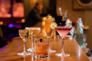 a group of four cocktails sitting on a bar at The Oxbow Hotel in Eau Claire