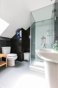 a bathroom with a sink and a toilet and a shower at Guest House Porto Clerigus in Porto