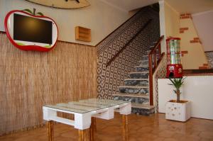 a living room with a table and a tv on a wall at SwordFish Eco-House Peniche in Peniche