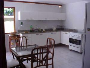 cocina con mesa, sillas, mesa y mesa en Casa em Búzios Geribá luxo 5 suites, en Búzios