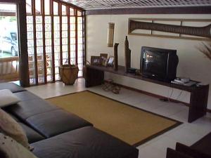 sala de estar con sofá y TV en Casa em Búzios Geribá luxo 5 suites, en Búzios