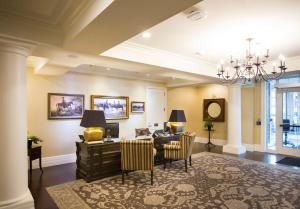 a living room with a table and chairs and a chandelier at The Atherton Hotel at OSU in Stillwater