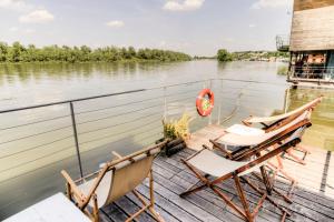 two chairs sitting on a dock next to the water at ArkaBarka 2- Floating Dream Rooms and Apartments in Belgrade