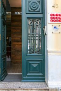 a green door with a metal gate on a building at Guest House Porto Clerigus in Porto