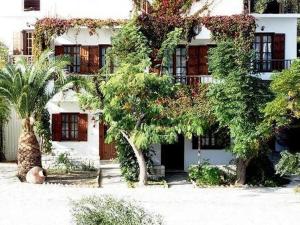 ein weißes Gebäude mit Bäumen davor in der Unterkunft Korali in Órmos Marathokámpou + 23 Fotos