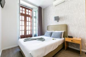 a bedroom with a bed with a bow tie on it at Guest House Porto Clerigus in Porto