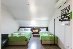 a small room with two beds and a couch at Guest House Porto Clerigus in Porto