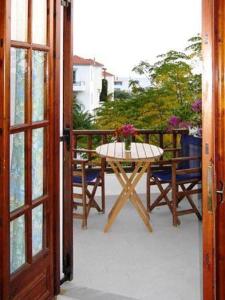 ein Tisch mit einer Vase mit Blumen auf einem Balkon in der Unterkunft Korali in Órmos Marathokámpou