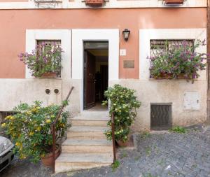 a stairway leading to a house with flowers in windows at Monti Guest House - Affittacamere in Rome