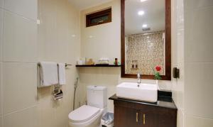 a bathroom with a white toilet and a sink at The Somerset Hotel in Male City