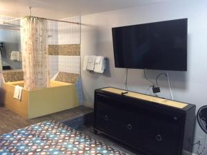 a bedroom with a flat screen tv on the wall at Sea Garden Motel in Pismo Beach