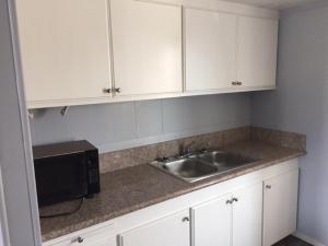 a kitchen with a sink and a microwave at Sea Garden Motel in Pismo Beach