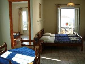 ein Schlafzimmer mit zwei Betten und einem großen Fenster in der Unterkunft Korali in Órmos Marathokámpou