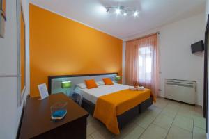 1 dormitorio con 1 cama con manta naranja en Kristal, en San Vito lo Capo