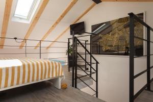 ein Loft mit einem Bett und einer Treppe in der Unterkunft Apartments Stube 4 in Rovinj