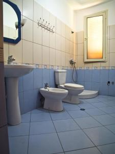 a bathroom with two toilets and a sink and a mirror at Apartments Vila Cala in Durrës