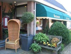 une chaise et des plantes devant un magasin dans l'établissement Hotel de Admiraal, à Noordwijk aan Zee