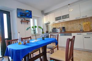 a kitchen and dining room with a blue table and chairs at Apartment Mambo in Sobra