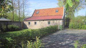 ein Haus mit einem orangenen Dach und einer Auffahrt in der Unterkunft loonse huis in Loon op Zand