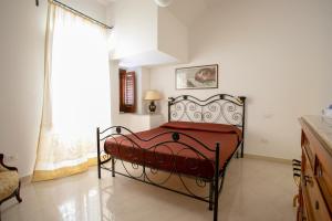 ein Schlafzimmer mit einem roten Bett in einem Zimmer mit einem Fenster in der Unterkunft Appartamento Piazza Pretoria in Palermo