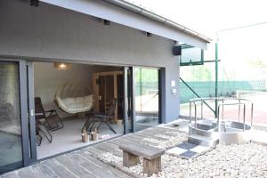 une maison en verre avec un banc sur une terrasse dans l'établissement Penzion Víno Hruška Blatnička, à Blatnička