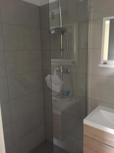 a shower with a glass door next to a sink at Pokoje Gościnne U Broni in Mielno +18 photos