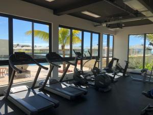 a gym with cardio machines and a view of the beach at Azuri Appartements De Luxe in Roches Noires
