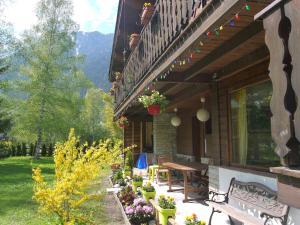 une terrasse couverte d'une maison avec une table en bois et des bancs dans l'établissement Chalet Champraz - Free Parking, à Chamonix-Mont-Blanc