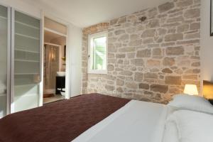 ein Schlafzimmer mit einer Steinmauer und einem Bett in der Unterkunft Apartment Istra in Rovinj