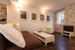 ein Wohnzimmer mit einem Sofa und einem TV in der Unterkunft Apartment Istra in Rovinj